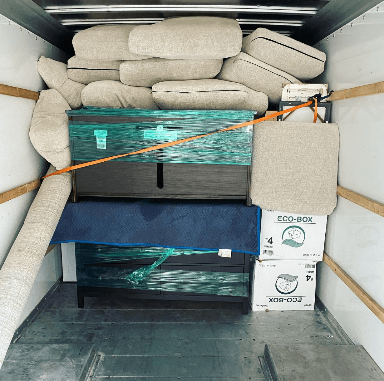 Moving truck loaded with wrapped couches and bedroom furniture for a local move.